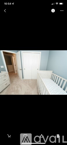 A room with a white door and a white bed.