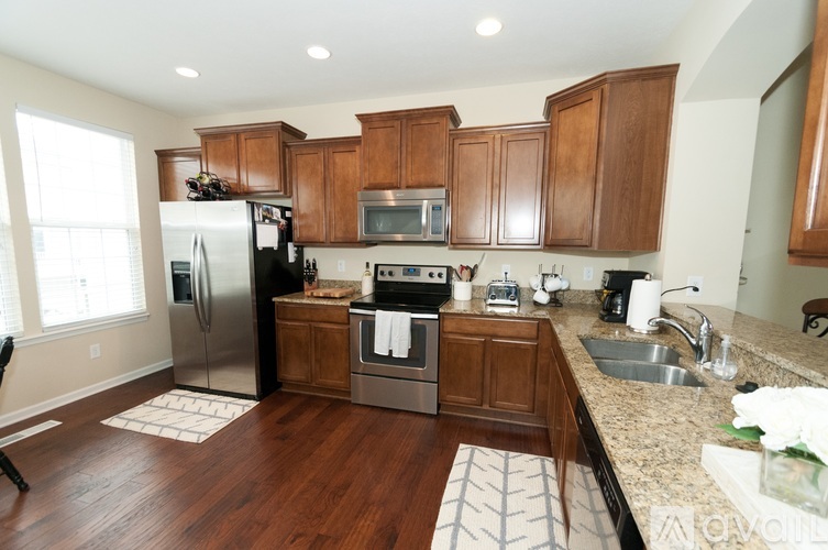 A kitchen with wooden cabinets and a stainless steel refrigerator.