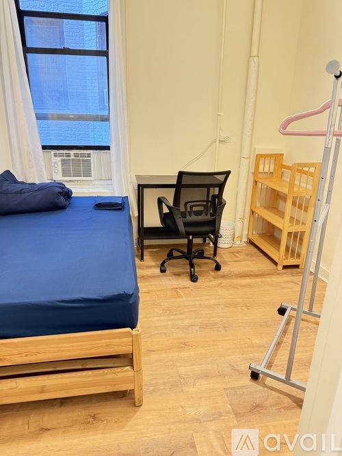 A room with a bed, a chair, and a ladder.