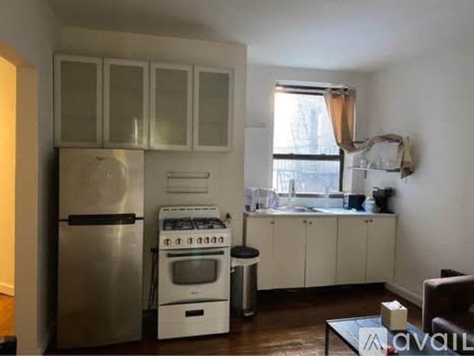 A kitchen with a refrigerator, oven, and cabinets.