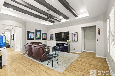A living room with a brown leather couch and a glass coffee table.