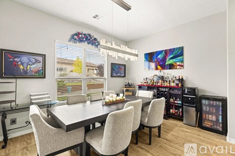 A dining room with a table set for four and a bar area with a television.
