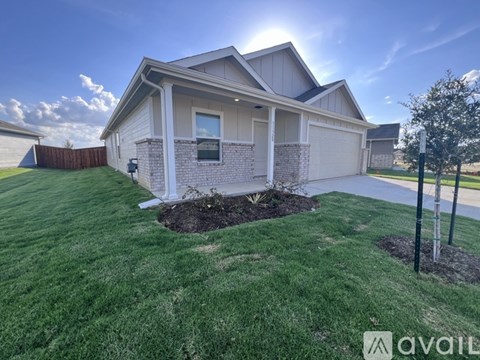 A house with a well-maintained lawn and a clear sky above.