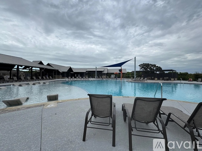 Two chairs are placed on a patio next to a pool.