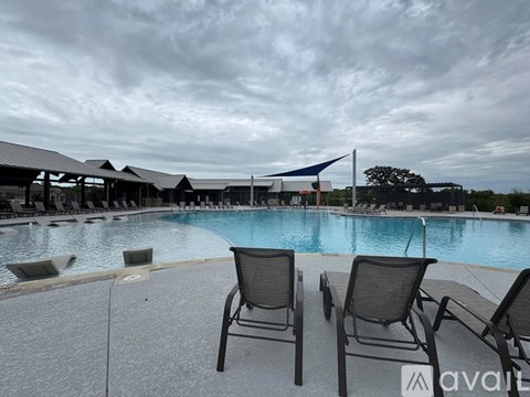 Two chairs are placed on a patio next to a pool.