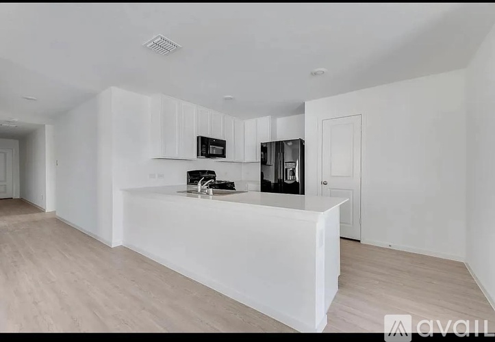A modern kitchen with white cabinets and a white island.