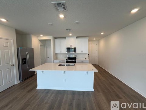 A kitchen with white cabinets and a wooden island.