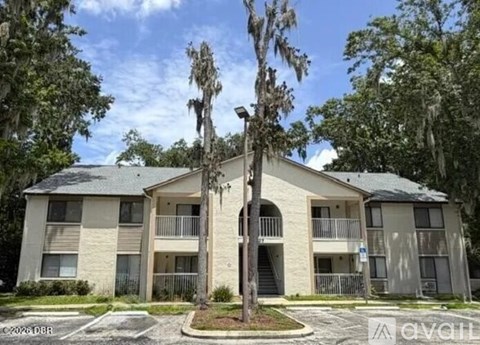 A building with a balcony and a tree in front of it.