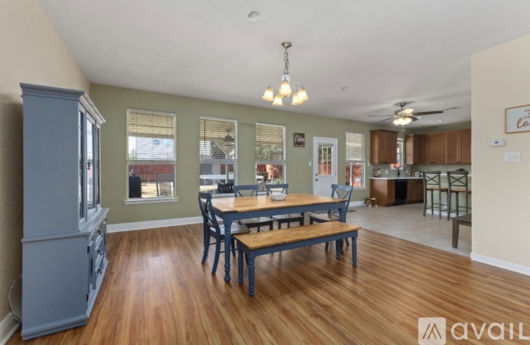 A kitchen with a dining table and chairs in the middle of the room.