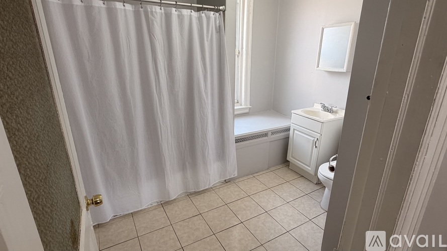 A bathroom with a white shower curtain and a white sink.