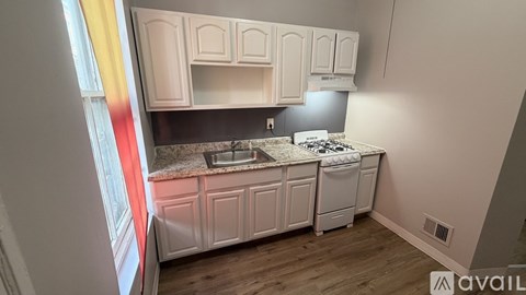 A kitchen with white cabinets and a granite countertop.