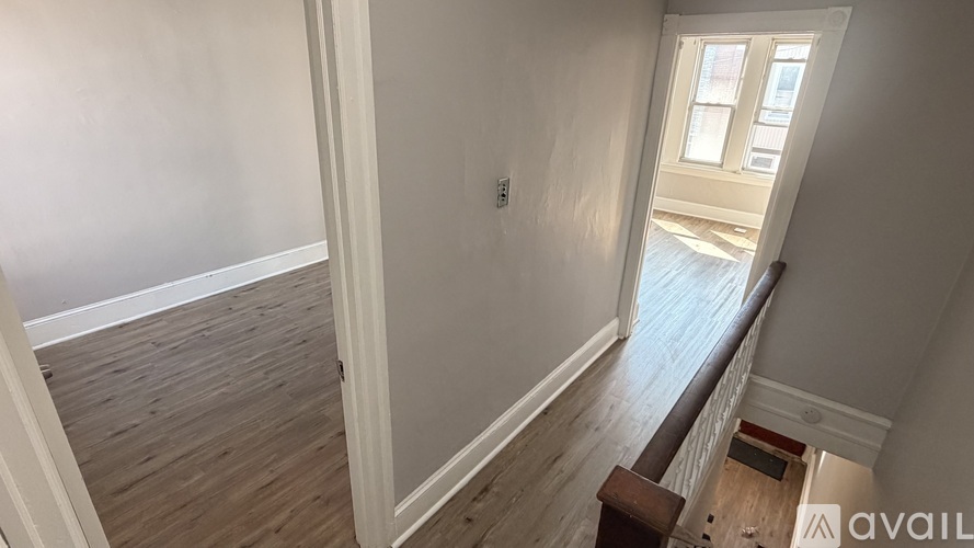 A room with wooden flooring and a window.