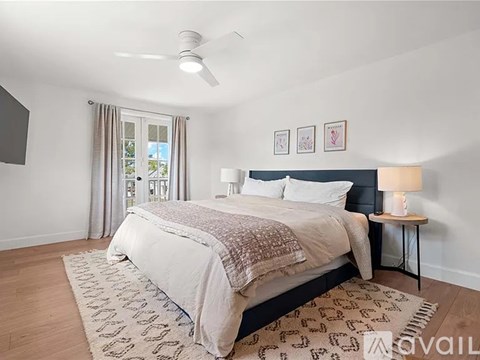 A bedroom with a large bed and a ceiling fan.