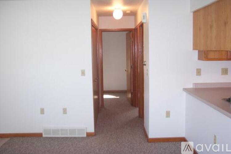 A room with a carpeted floor and a doorway leading to another room.