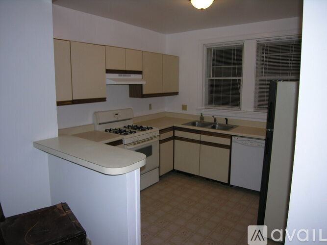A kitchen with a white counter top and beige cabinets.