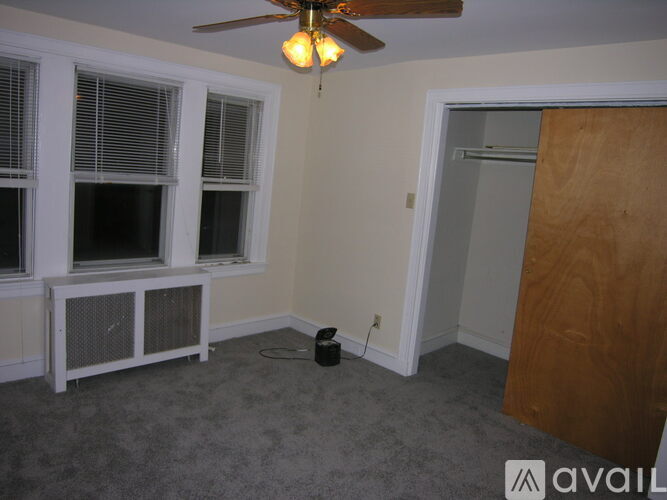 A room with a ceiling fan and a window with blinds.