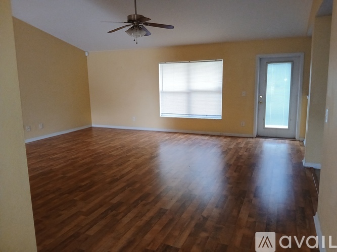 A room with wooden flooring and a ceiling fan.