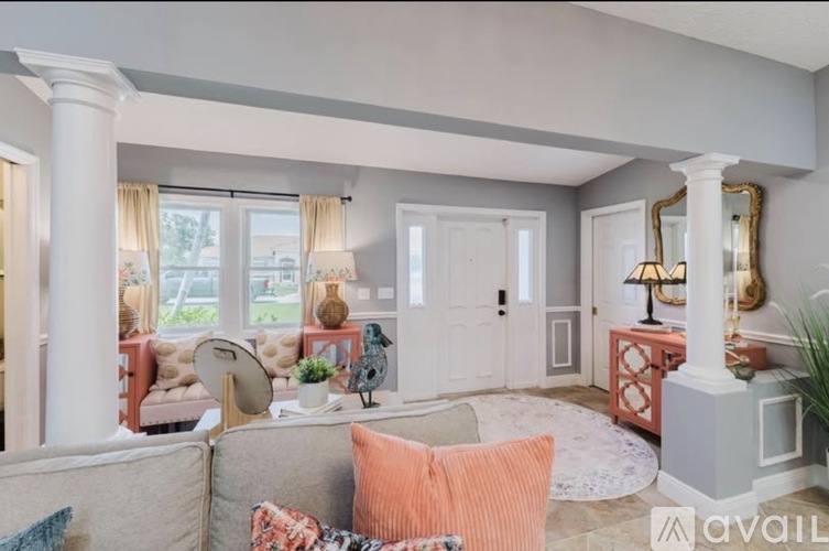 A living room with a grey couch and a white column.