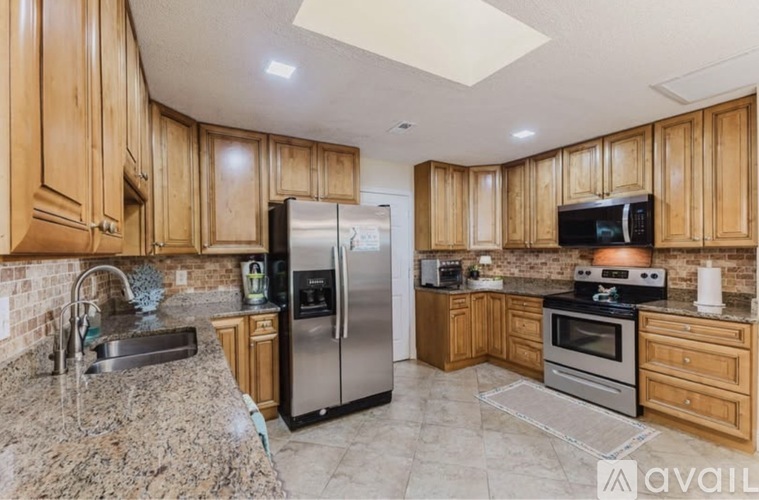 A kitchen with wooden cabinets and granite countertops.