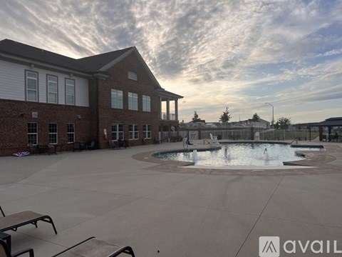 A large outdoor pool area with a building in the background.