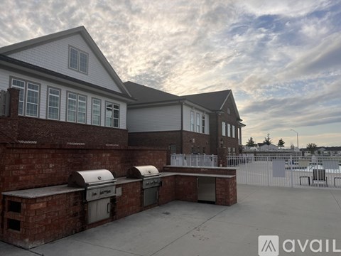 A house with a brick wall and a white roof is available for purchase.
