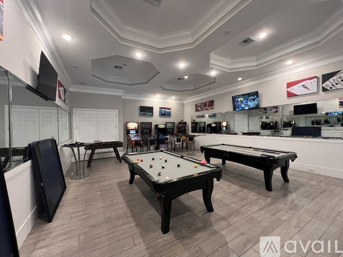 A room with a pool table and a TV mounted on the wall.