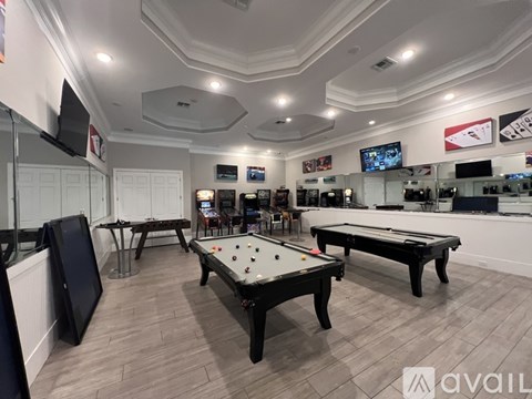 A room with a pool table and a TV mounted on the wall.