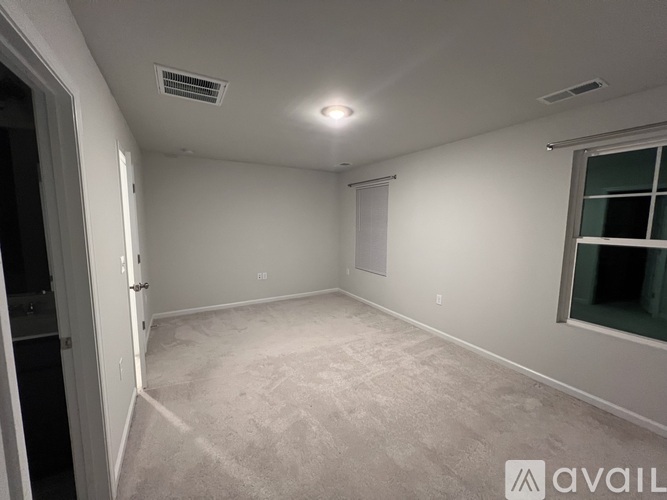 A spacious room with a window and a door.