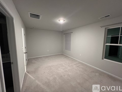 A spacious room with a window and a door.