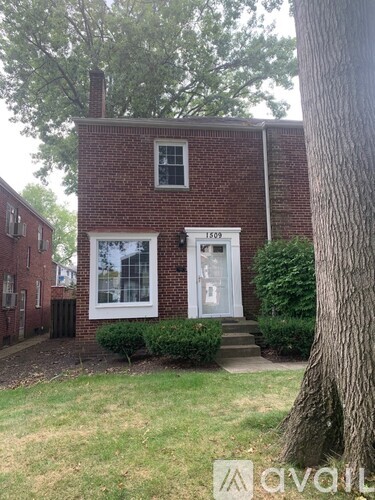 A brick house with a white door and window.