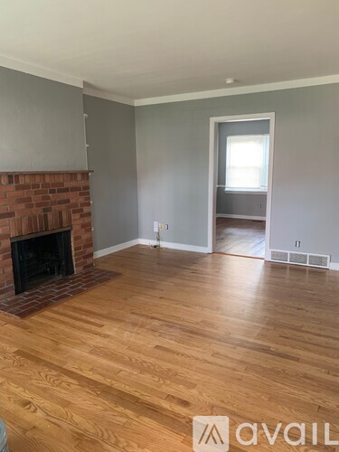 A room with a fireplace and wooden flooring.