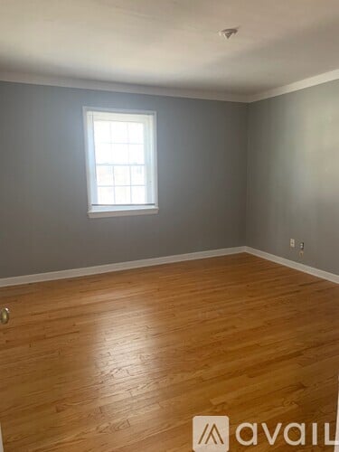 A room with wooden flooring and a window.