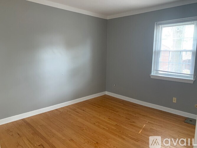 A room with wooden flooring and a window.