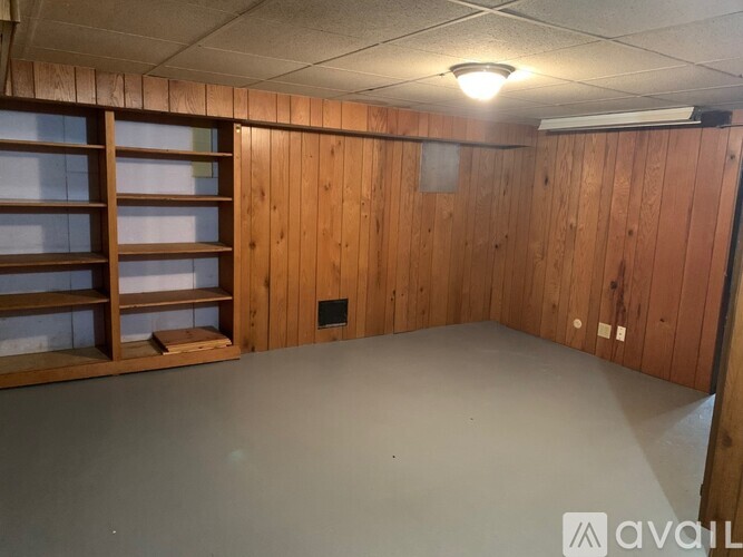 A room with wooden walls and a grey floor.