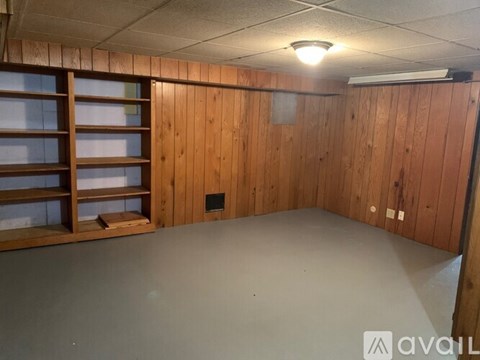 A room with wooden walls and a grey floor.