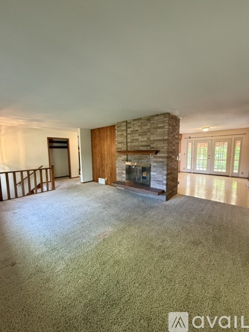 A living room with a fireplace and a carpet.