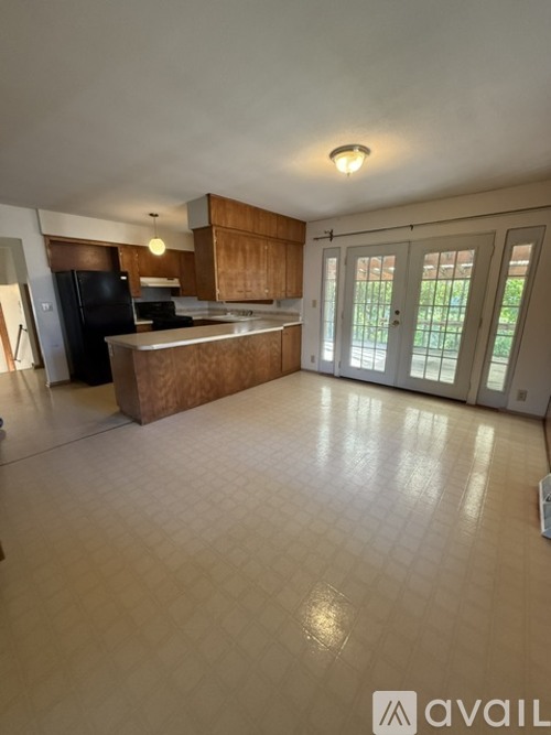 A kitchen with a refrigerator, sink, and cabinets.