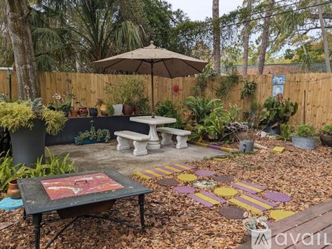 A backyard with a table and chairs and a bench.