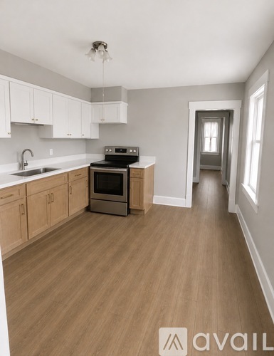 A kitchen with wooden floors and white cabinets.