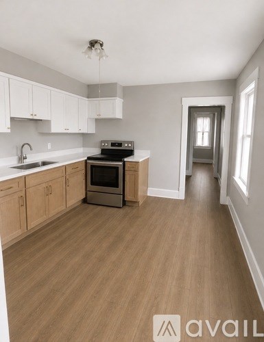 A kitchen with wooden floors and white cabinets.
