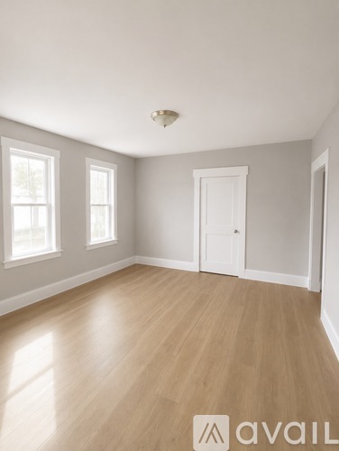 A room with wooden flooring and white walls.