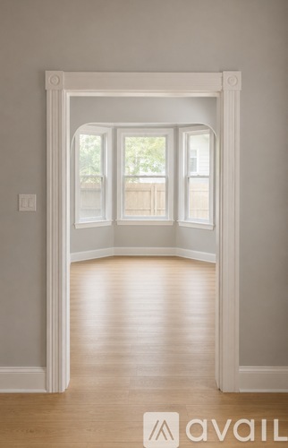 A room with a white door and wooden floor.