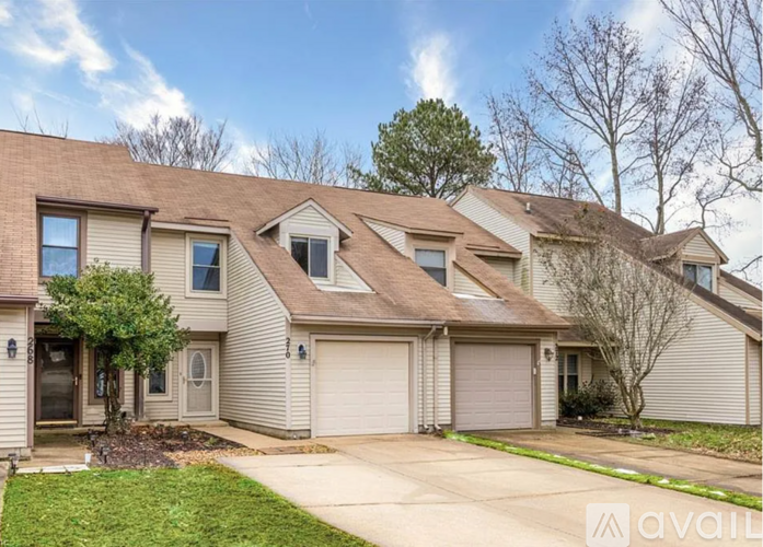 A house with a brown roof and a garage door is for sale.