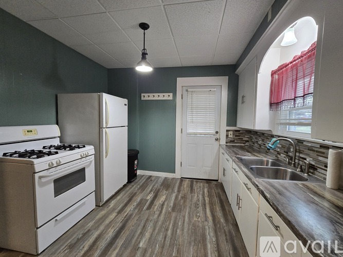 A kitchen with a white stove and a white refrigerator.