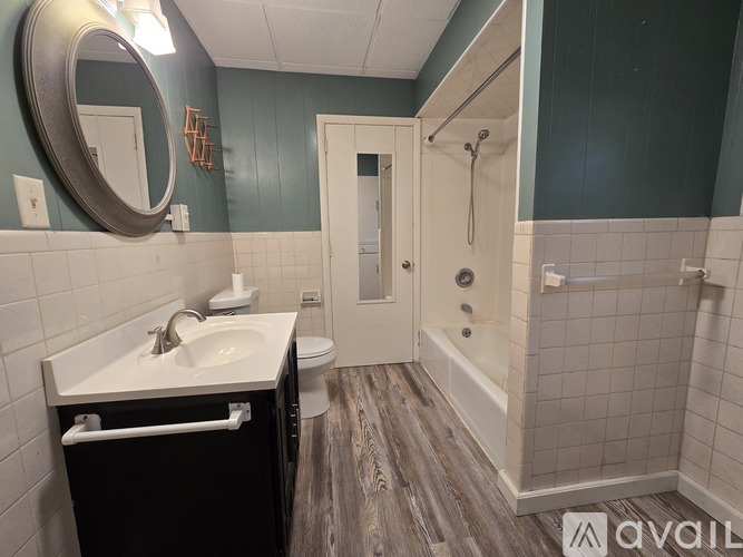 A bathroom with a sink, mirror, and shower.