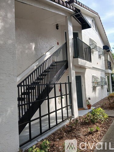 A white building with a black metal staircase.