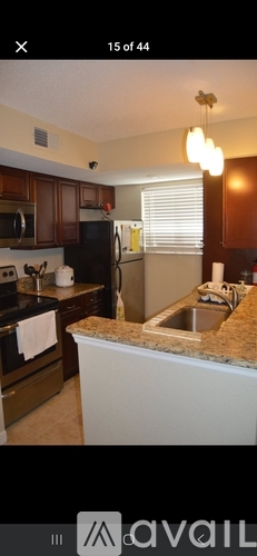 A kitchen with brown cabinets and a granite countertop.