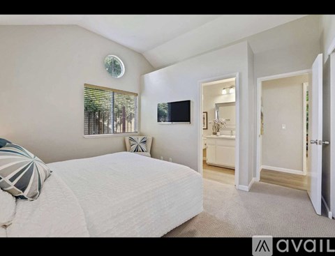 A bedroom with a large bed and a flat screen TV mounted on the wall.