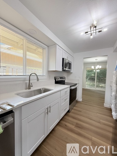 A kitchen with white cabinets and a sink.
