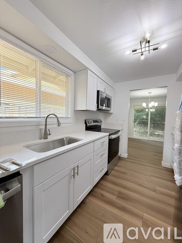 A kitchen with white cabinets and a sink.